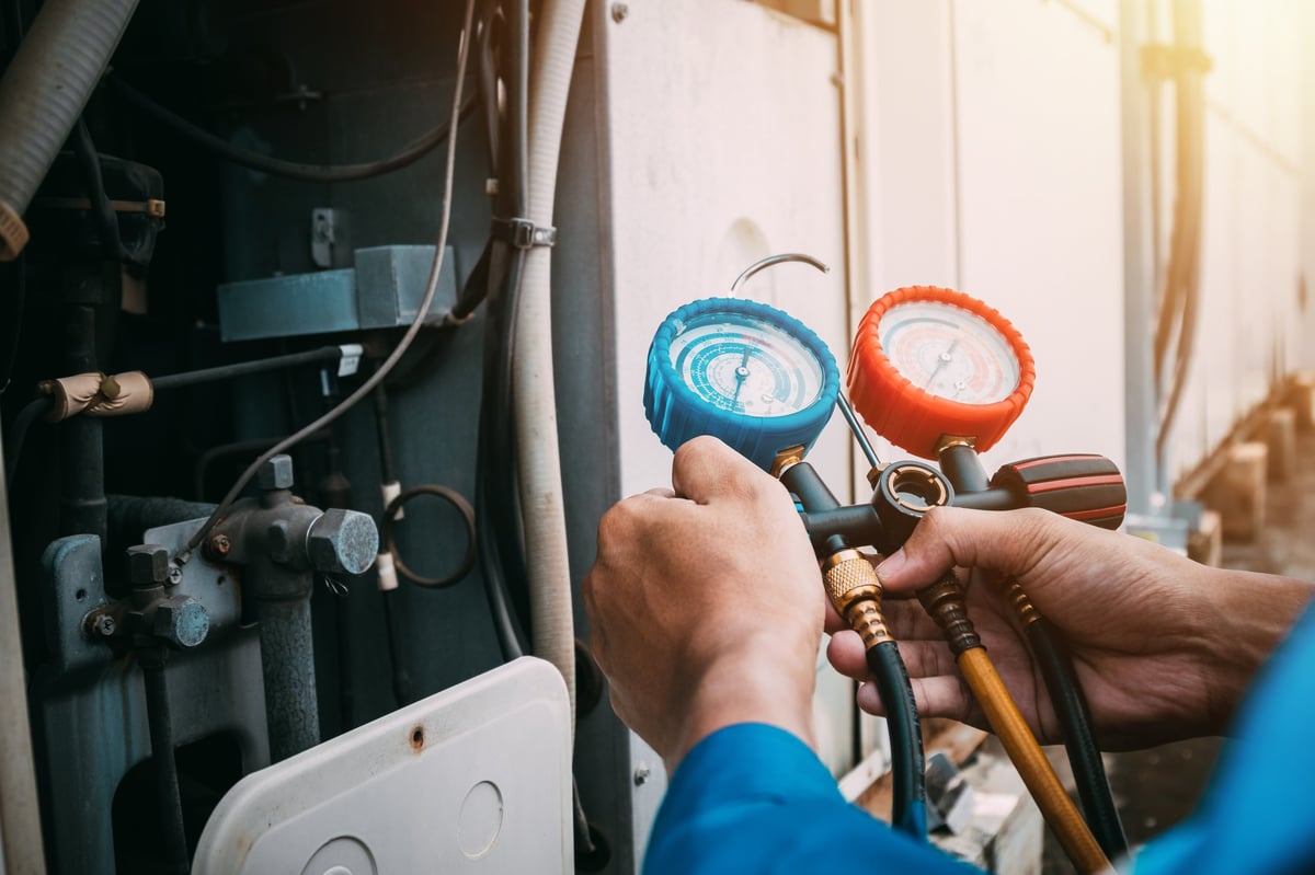 Technician checking air conditioner refrigerant leak