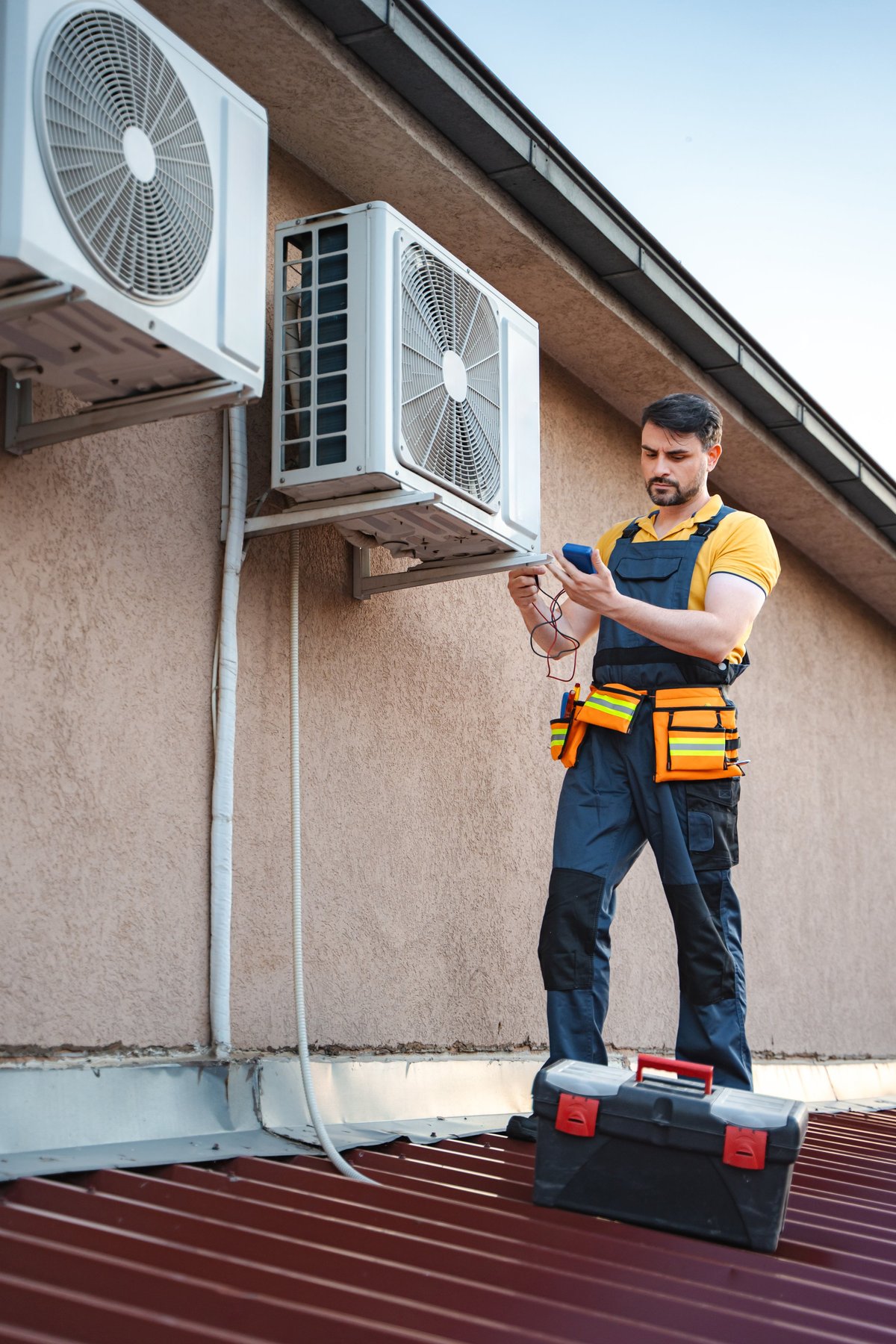 AC technician installing unit on roof