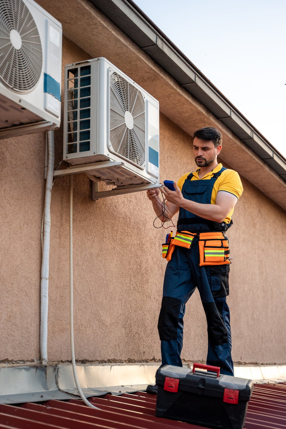 Technician inspecting rooftop AC units