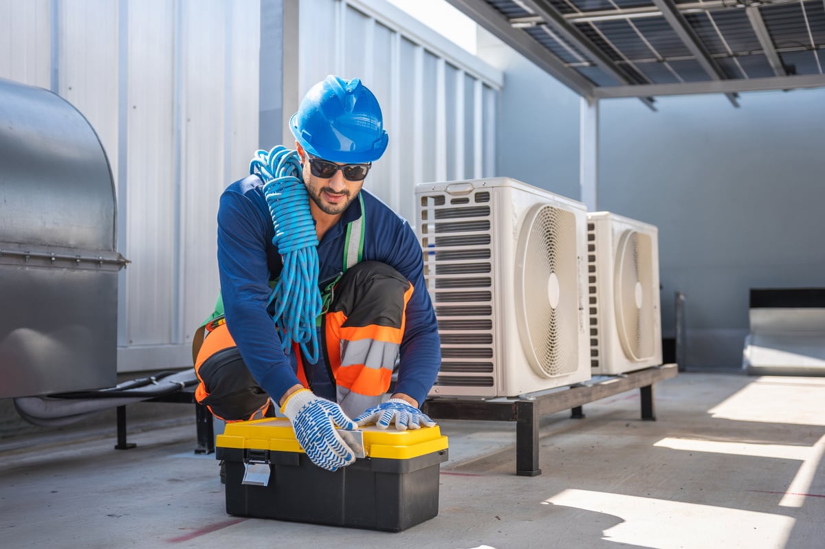 HVAC technician preparing tools on rooftop